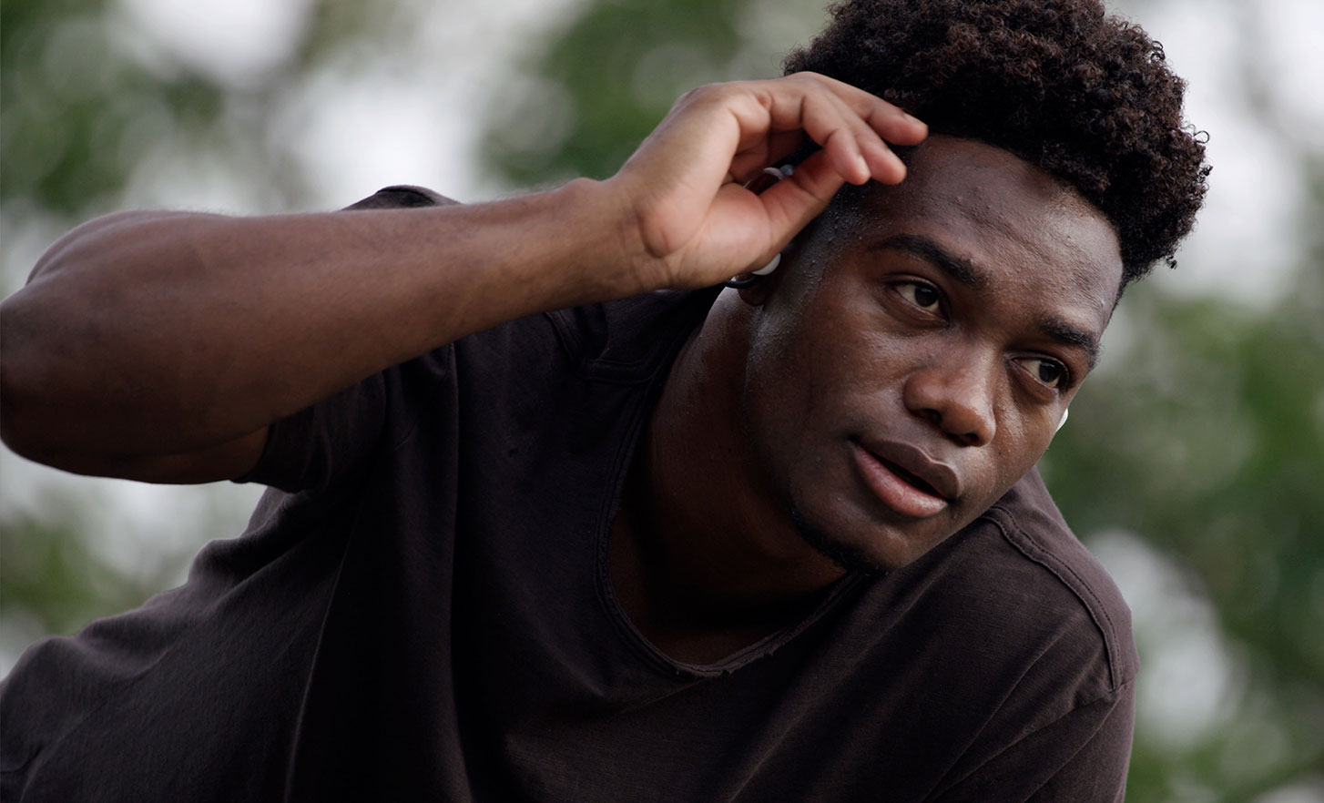 صورة رجل في الخارج يلامس جبهته ويرتدي سماعات الرأس Float Run من سوني