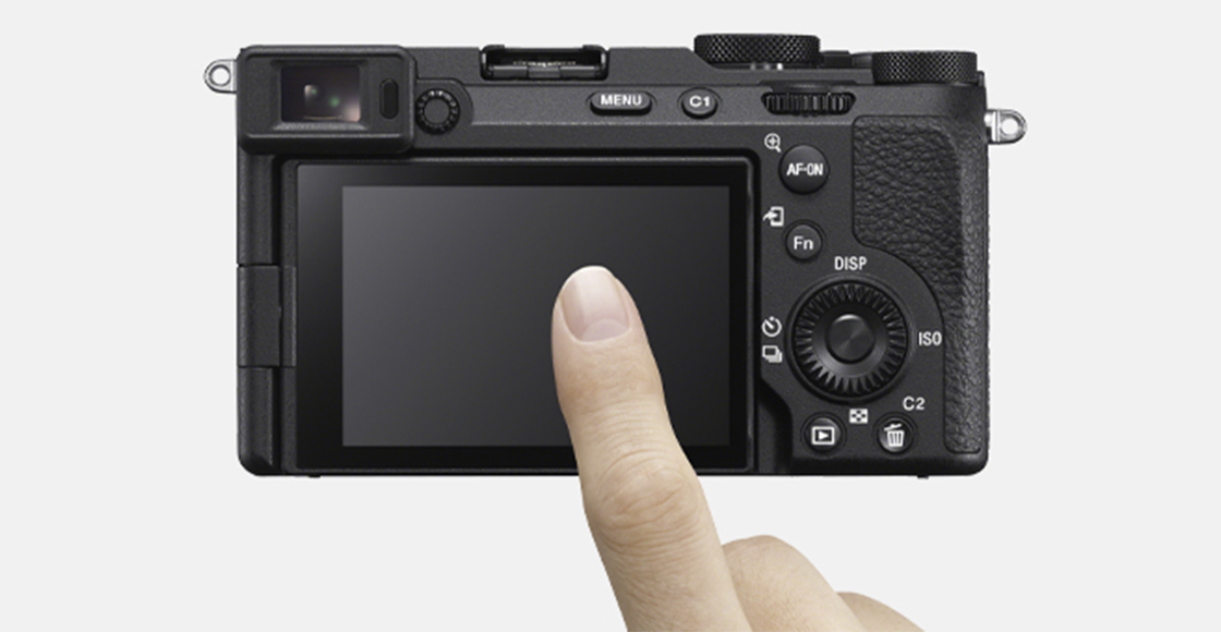Product image showing rear view of camera with user's finger operating touch screen